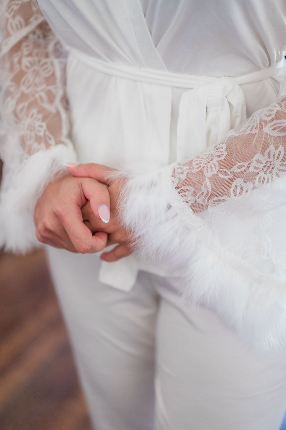 Close-up details of a white wedding dress with delicate lace and beading patterns on the fabric.