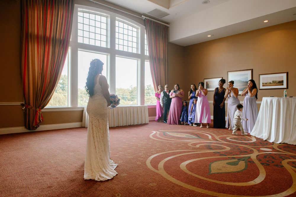Wedding celebration in an elegant ballroom with guests in pink and purple formal dresses.