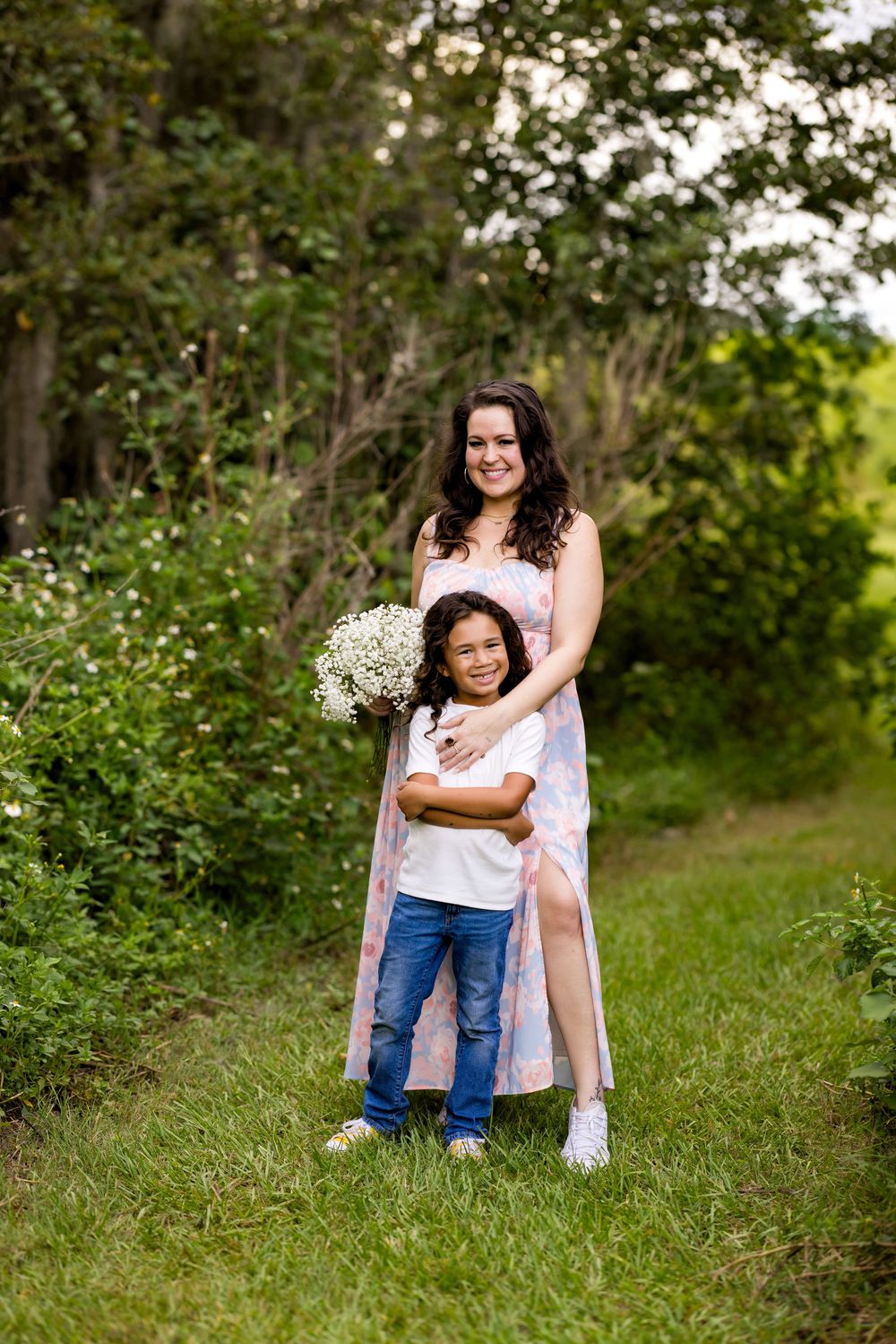 Two people share a joyful outdoor moment together surrounded by lush greenery and natural lighting in a park setting.