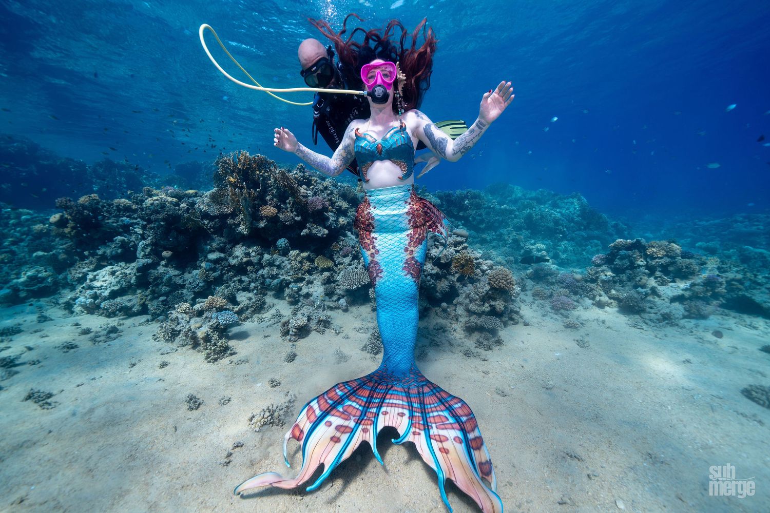 A scuba diver explores vibrant coral reefs in crystal clear turquoise waters off a tropical coast.