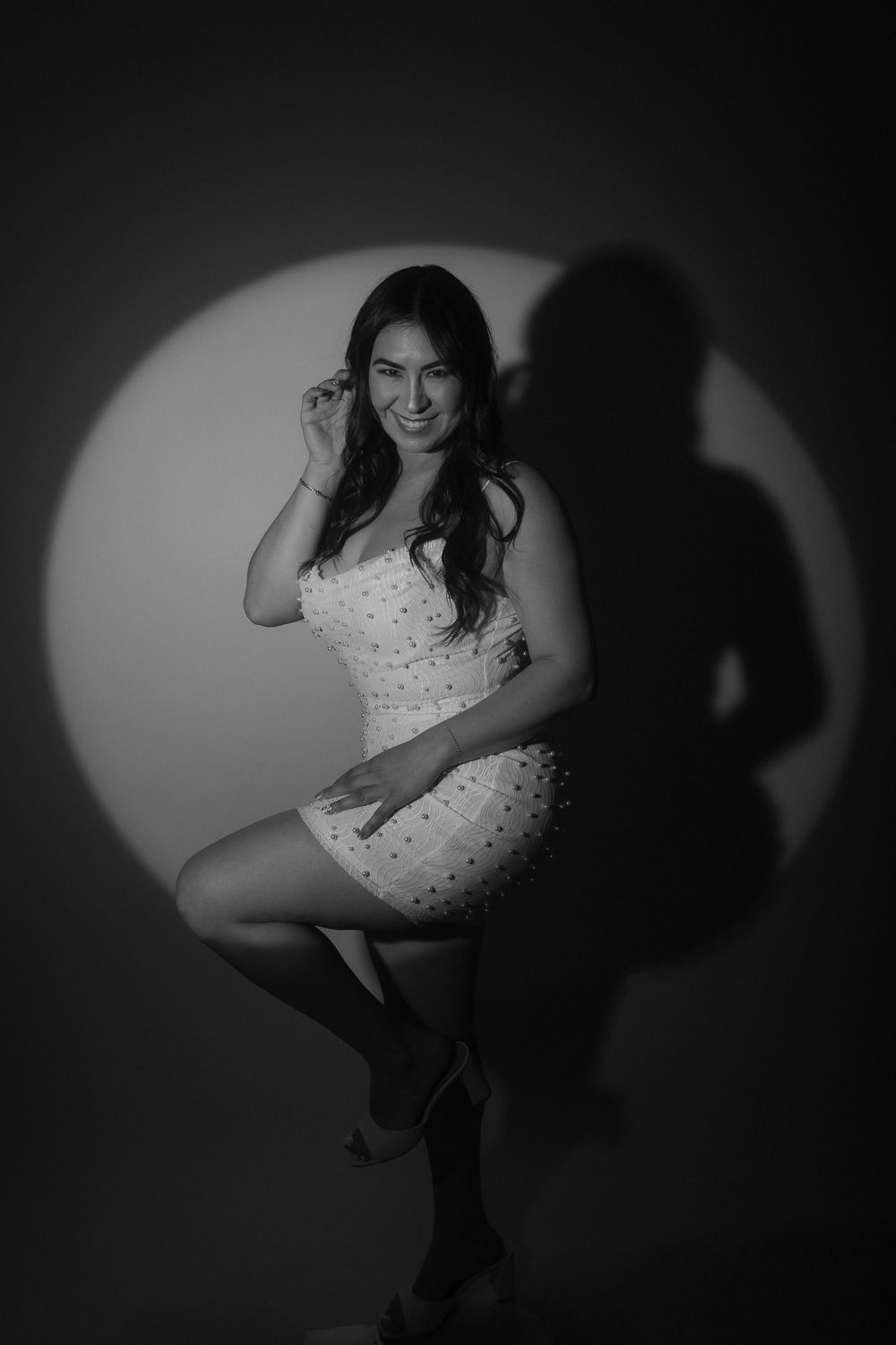 Artistic black and white boudoir photography series showing feminine poses against dark dramatic lighting.