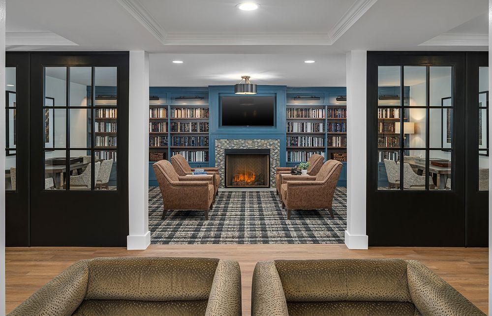 Modern office interior with library shelving and wood flooring showcases contemporary architectural design and lighting.