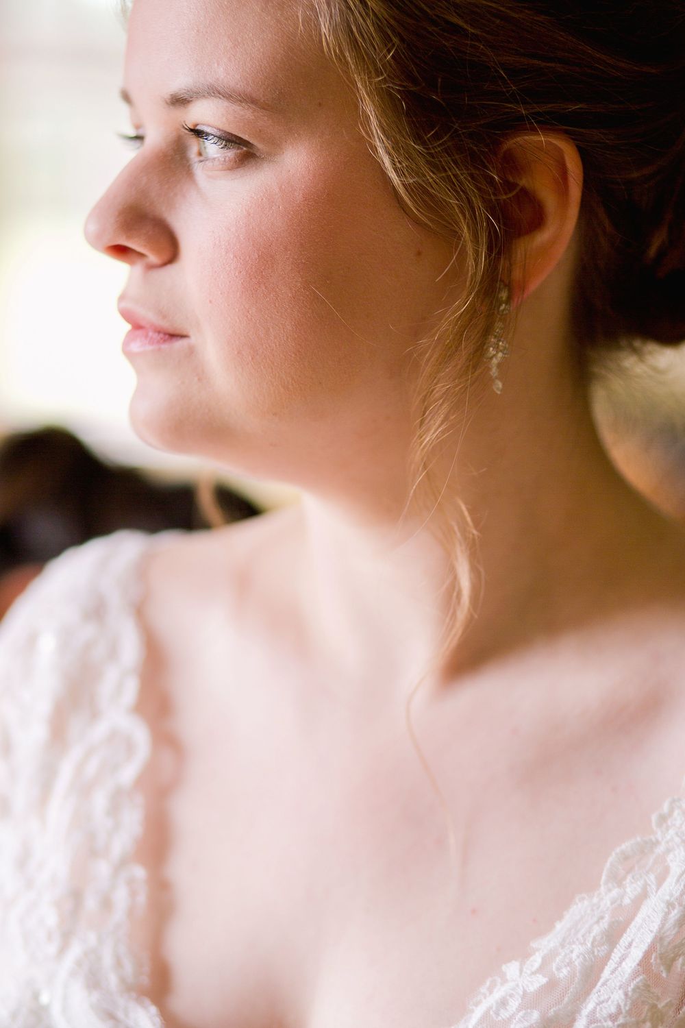 A bride in a white lace dress gazes off to the side in a series of soft, romantic profile portraits.
