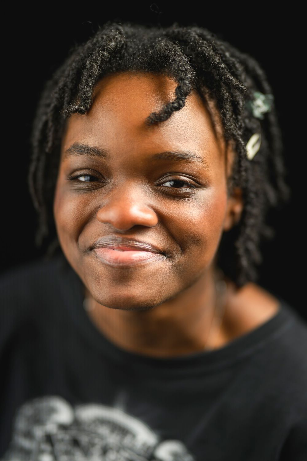 A close up portrait of a young black woman smiling and showing shallow depth of field