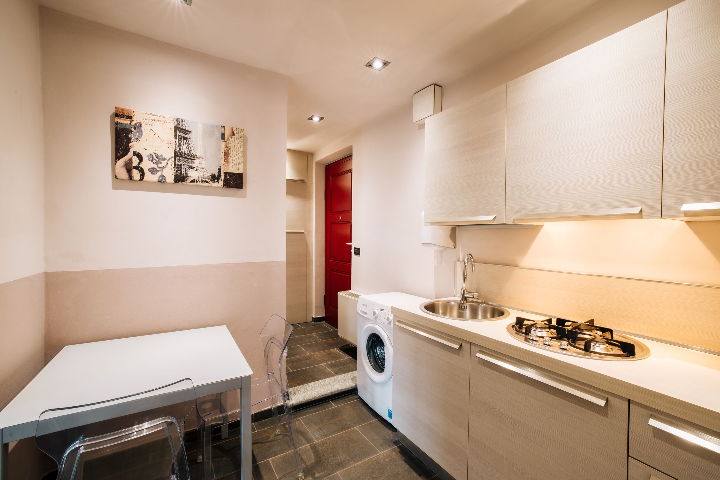 Modern white kitchen interior with sleek cabinets, built-in appliances and recessed lighting in a minimalist design.