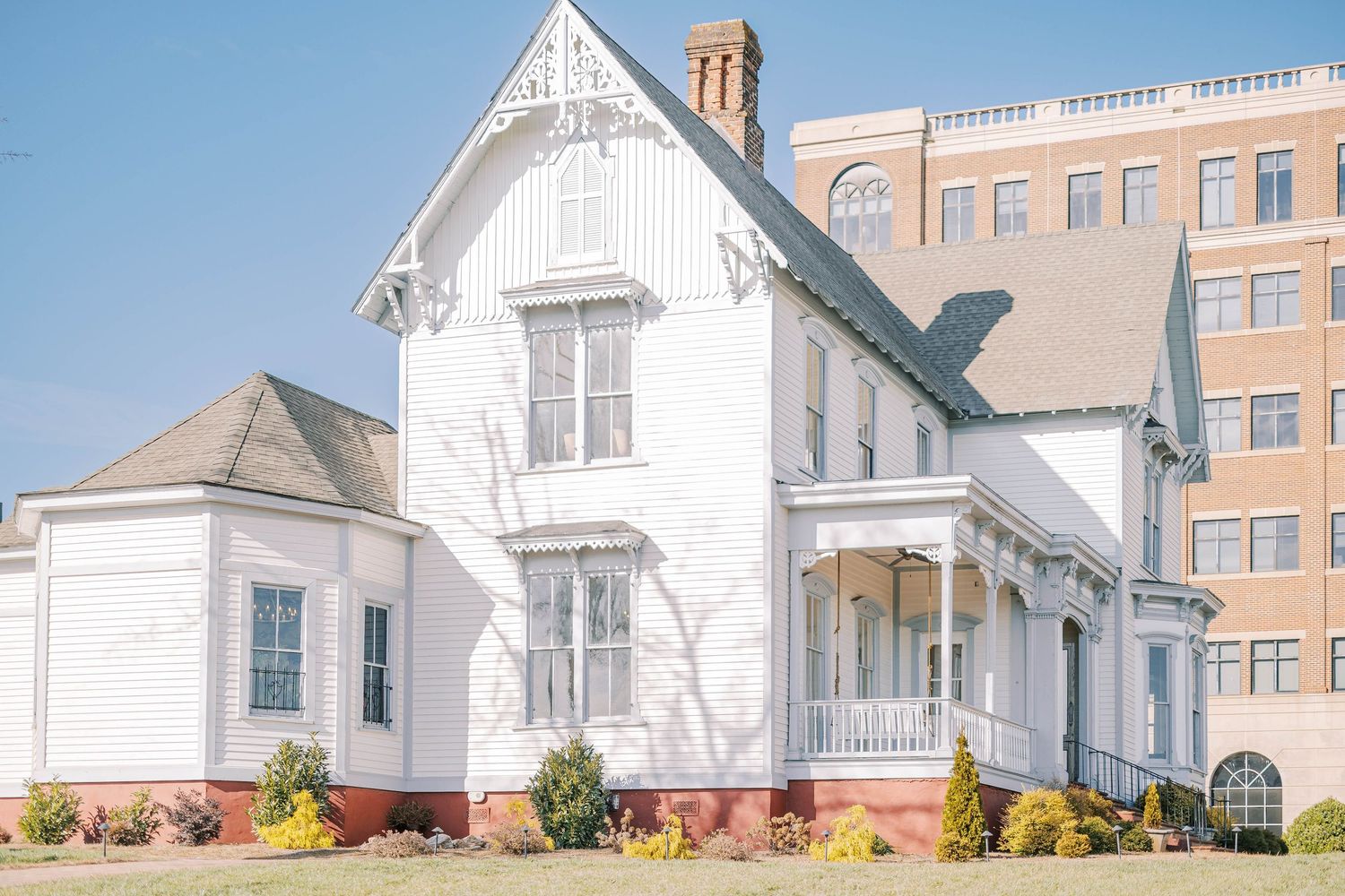 A series of white suburban houses with brick chimneys and architectural details shown in a panoramic view.