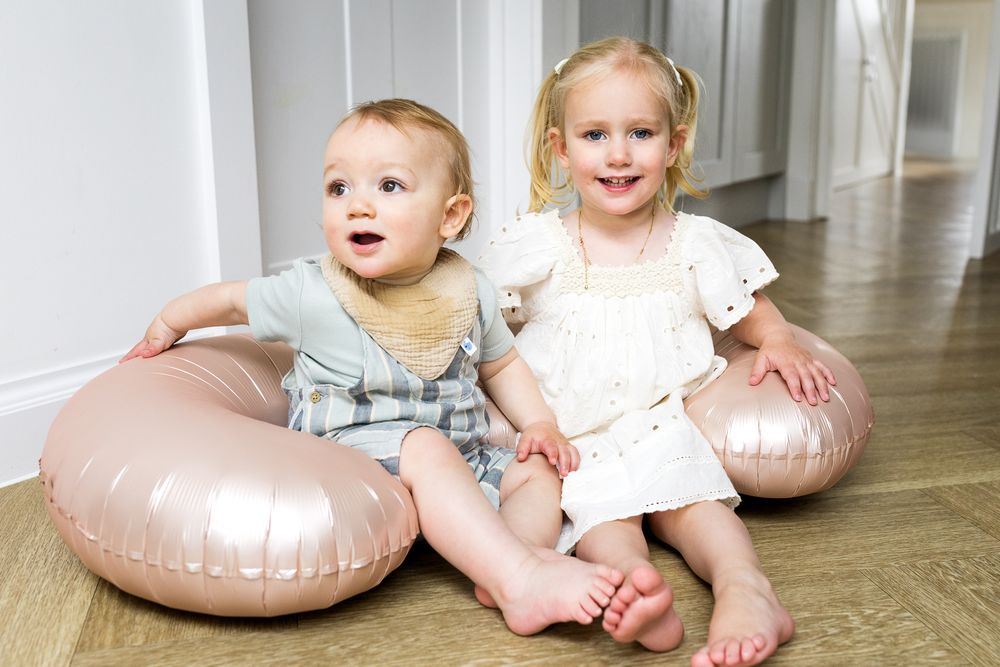 baby brother and big sister sitting together on the floor