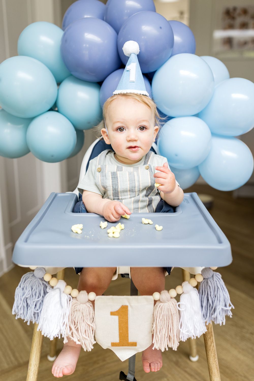 baby boy turning one year old surrounded by blue balloons