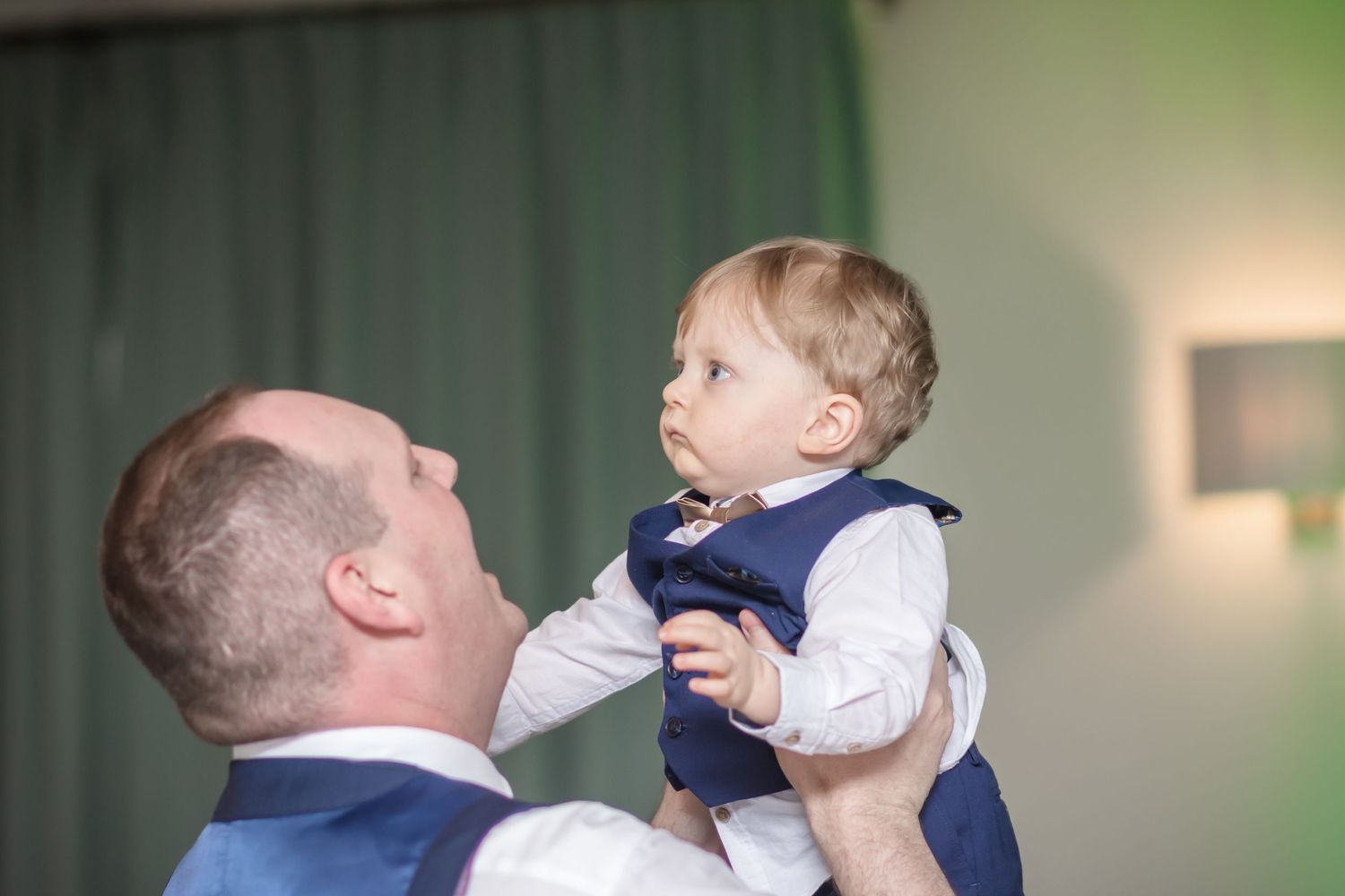 Wedding party members interact and laugh during a candid moment at the reception.