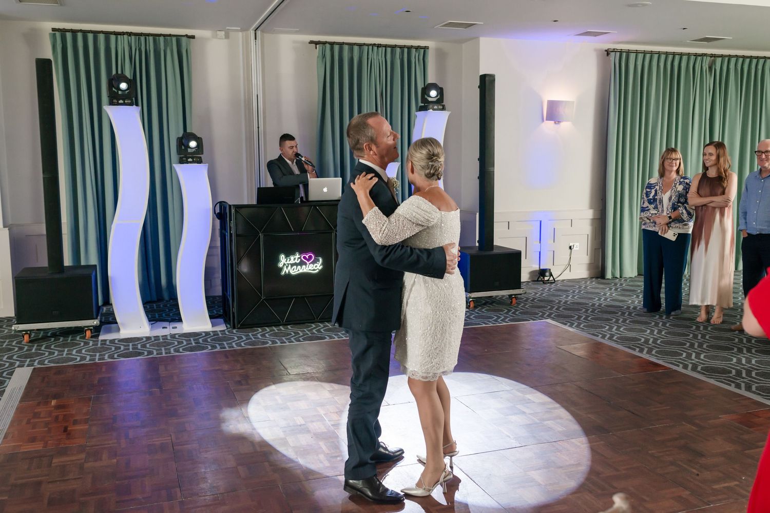 Wedding reception venue with green curtains and dance floor setup showing multiple candid moments.