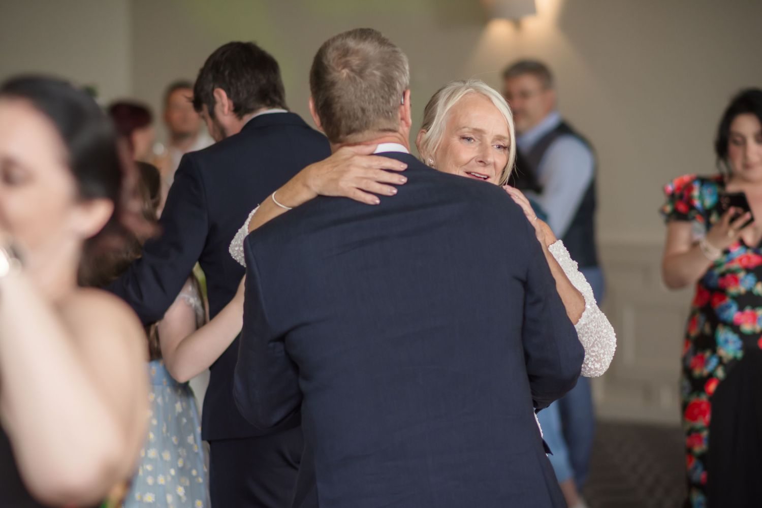 Couples dancing together during a wedding reception in an elegant ballroom setting.