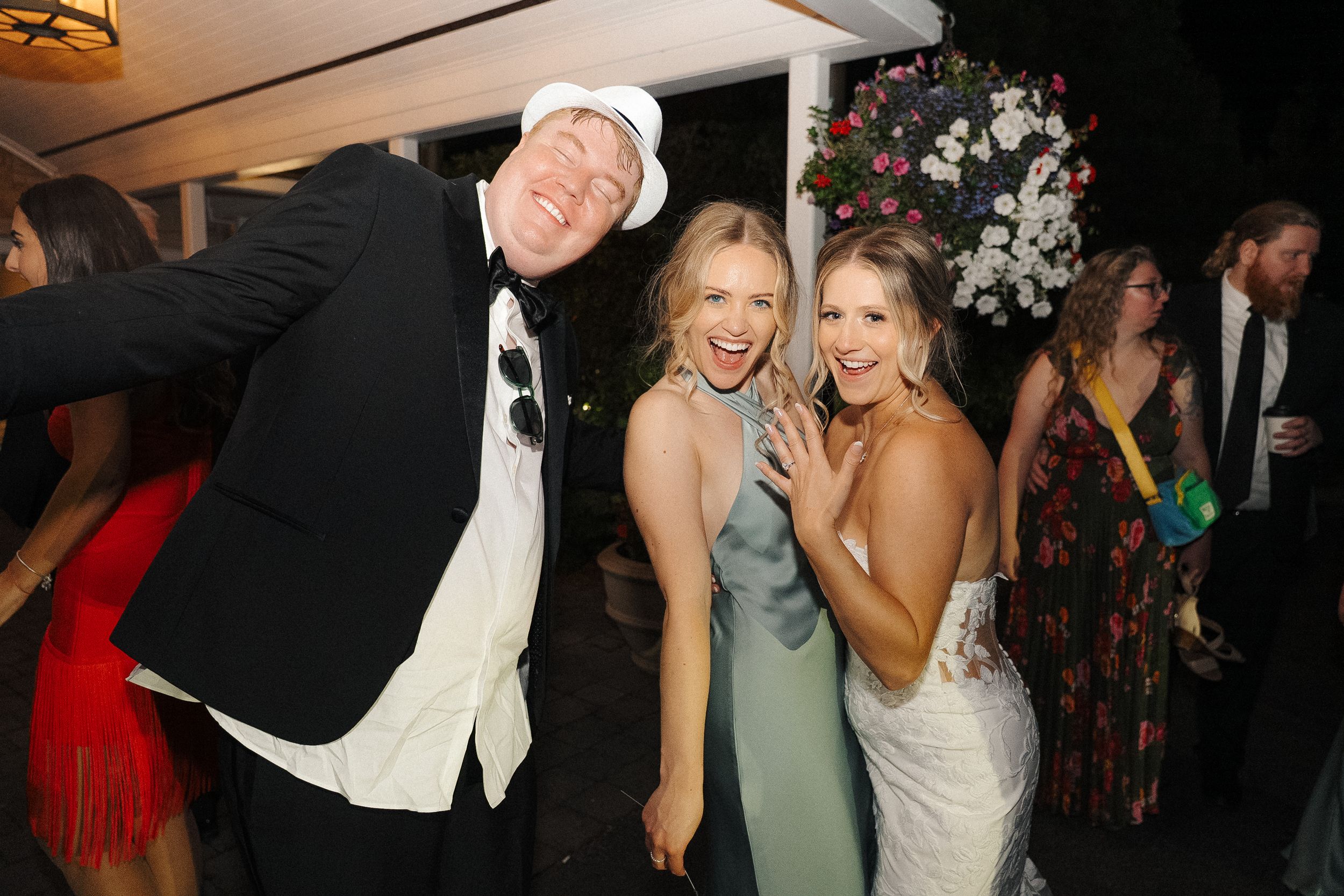 Guests celebrate joyfully at an elegant evening wedding reception party with festive formal attire.