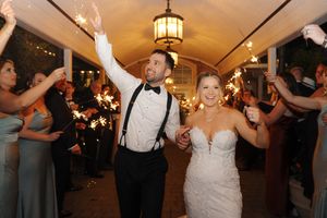 Wedding guests dance together on a dimly lit dance floor during an evening reception celebration.