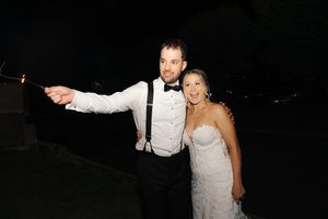 Wedding couple dances together on a dark dance floor during their reception celebration.