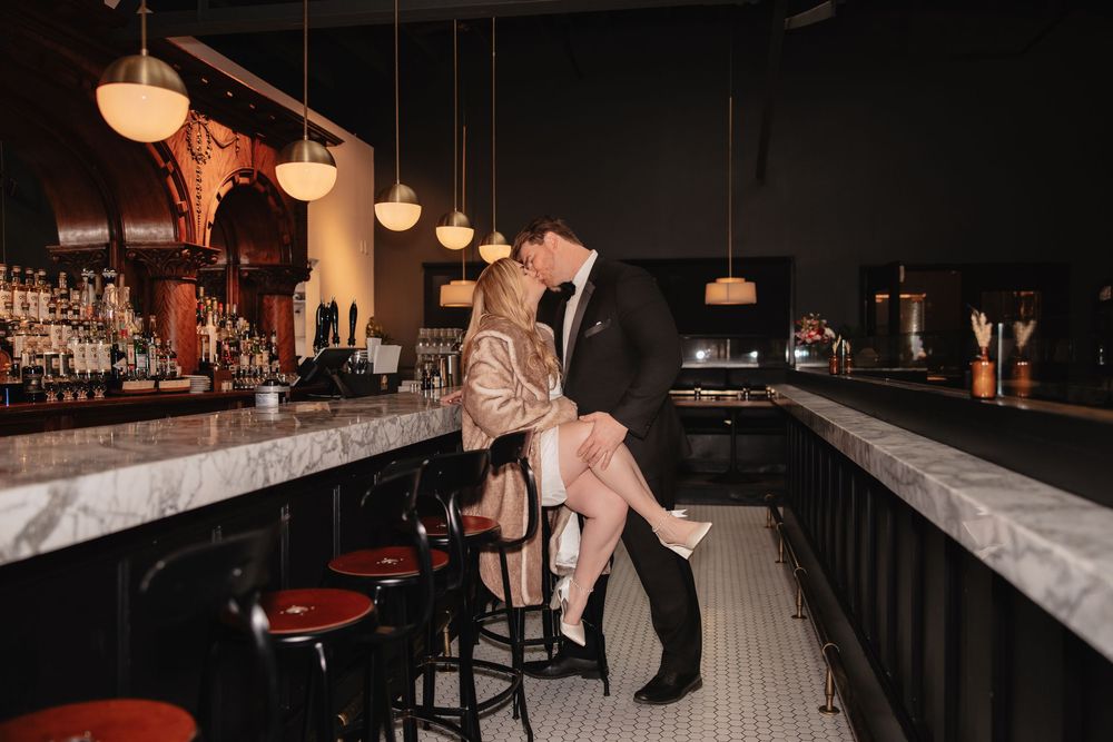 Moody bar interior with warm lighting features pendant lamps and dark wood furnishings creating an intimate atmosphere.
