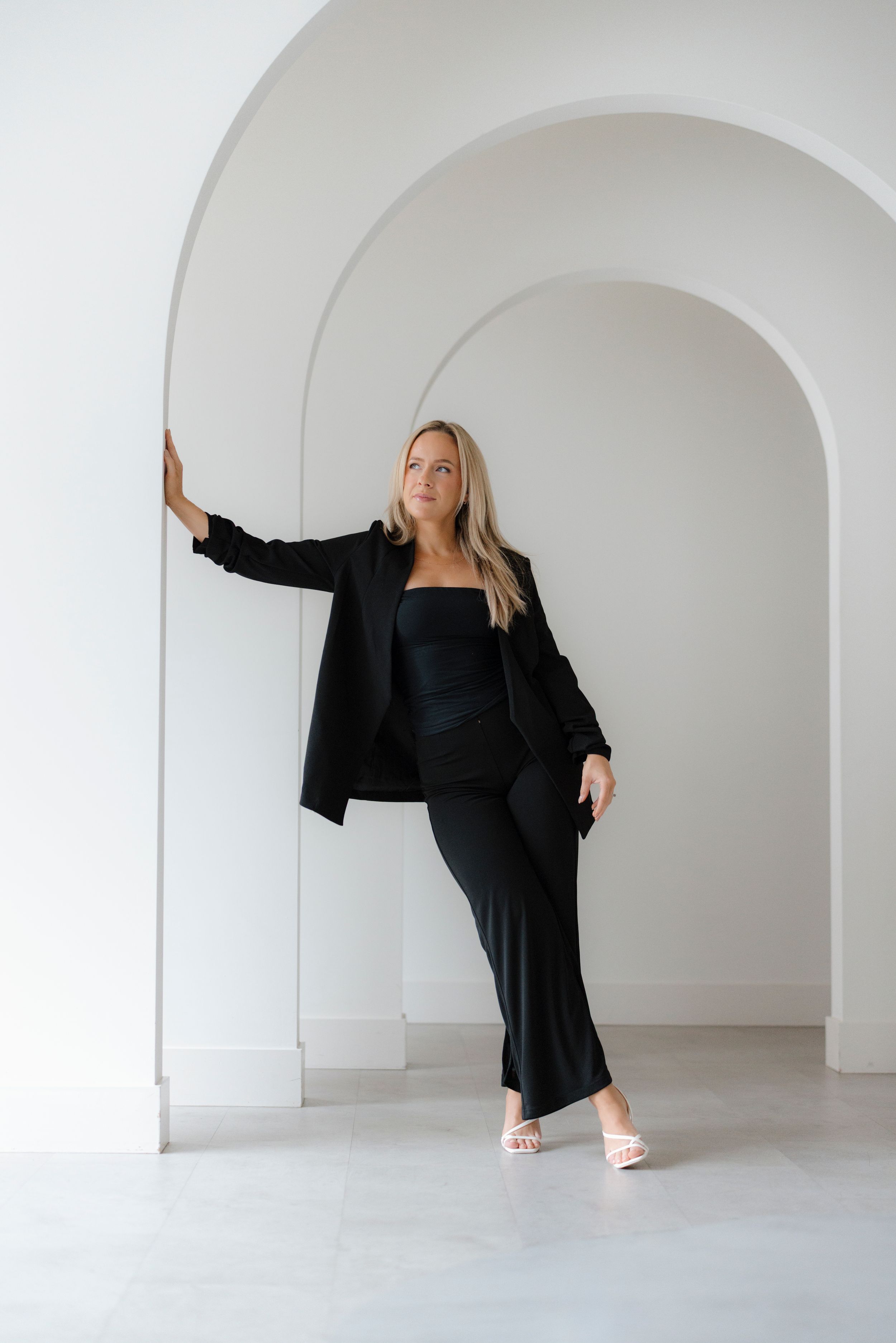 Artistic dance-like poses captured in sequence against white arched architecture.