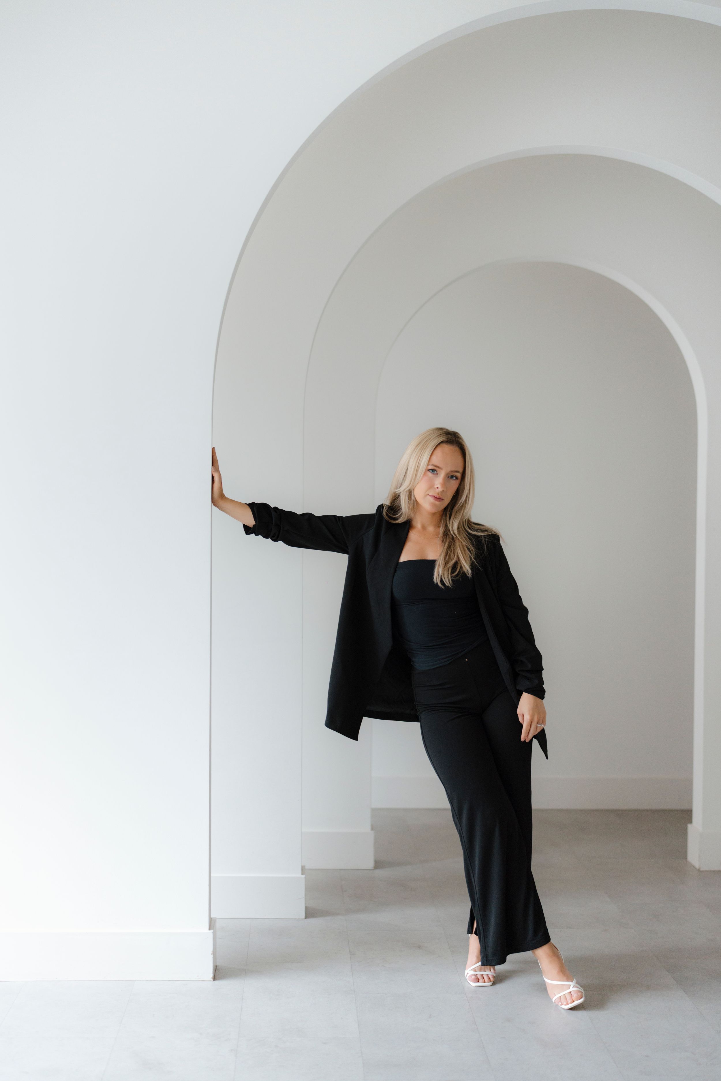 Artistic poses captured against clean white arched corridor backdrop.