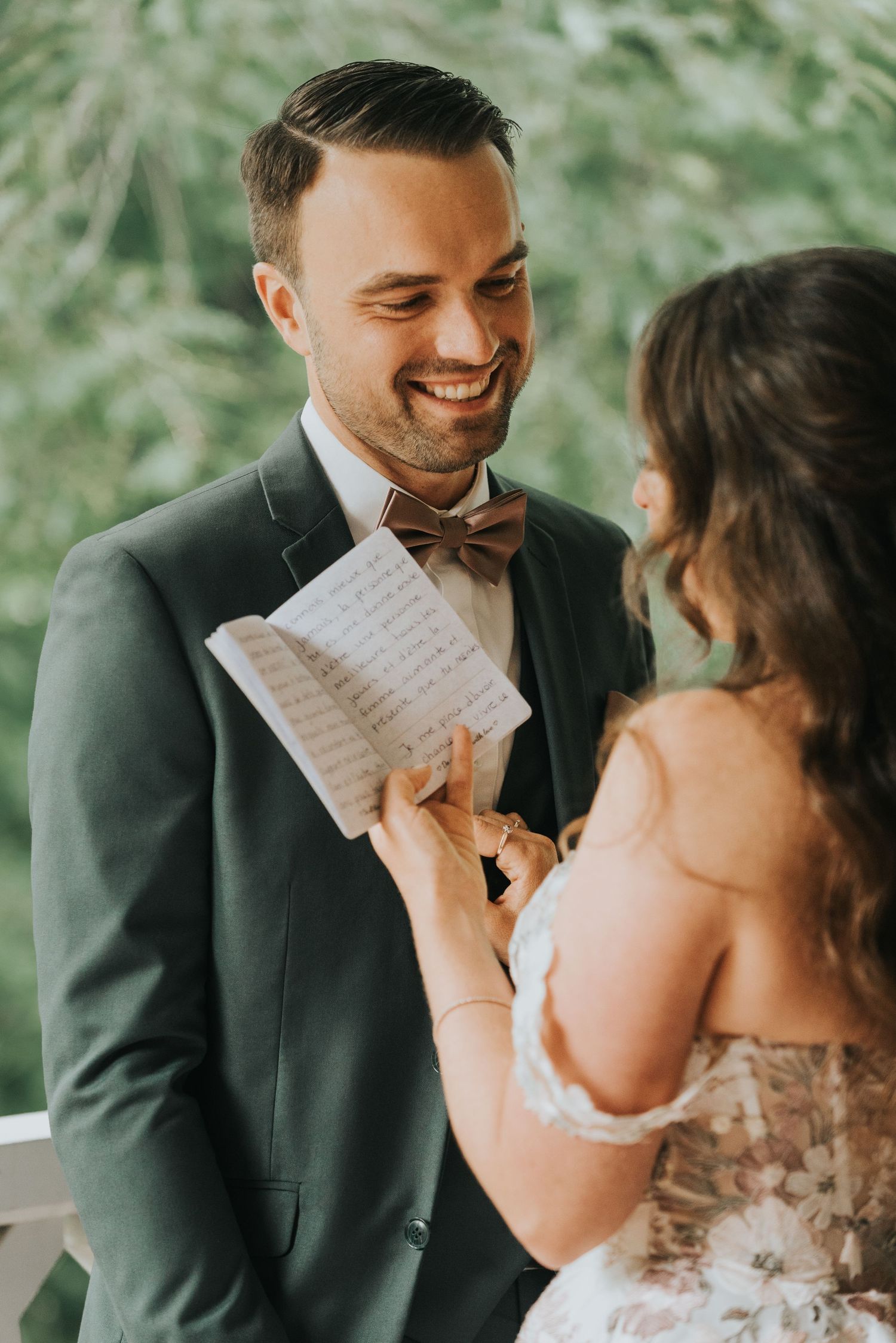 Couple sharing an emotional moment while reading handwritten vows during their wedding ceremony.