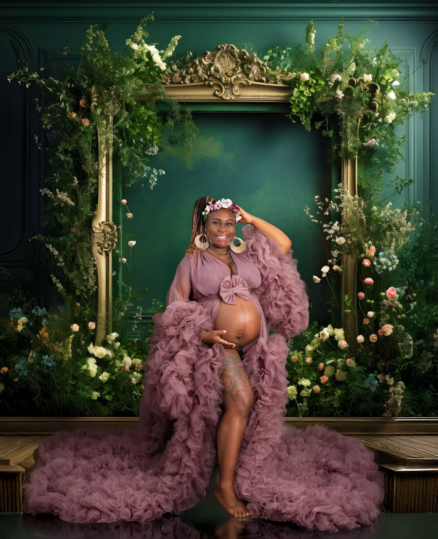 Elegant maternity photoshoot in front of ornate green wall with floral decor and golden frame.