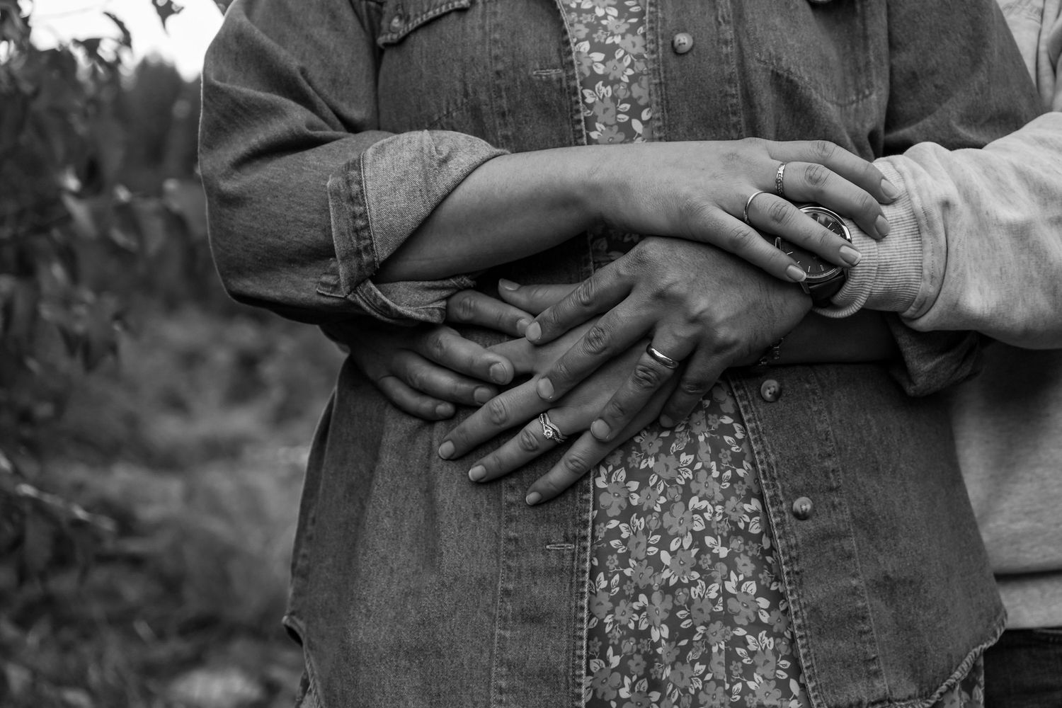 A series of black and white photographs showing a couple in wedding attire embracing in various romantic poses outdoors.