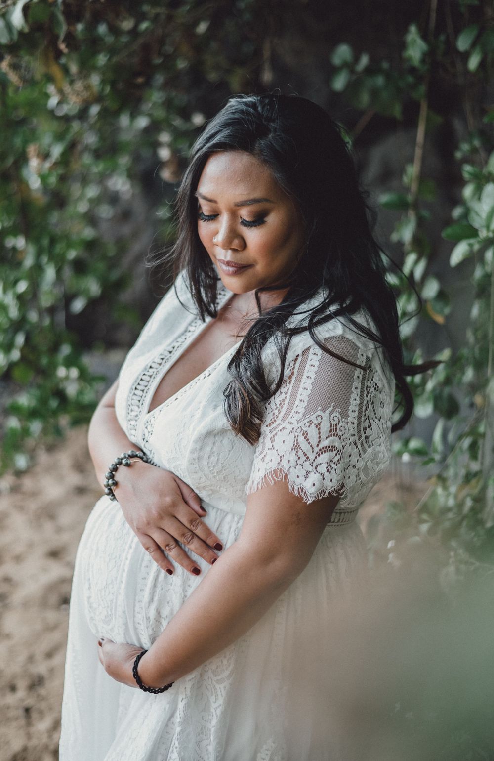 Delicate lace details of a white wedding dress shown in intimate beach portrait session.