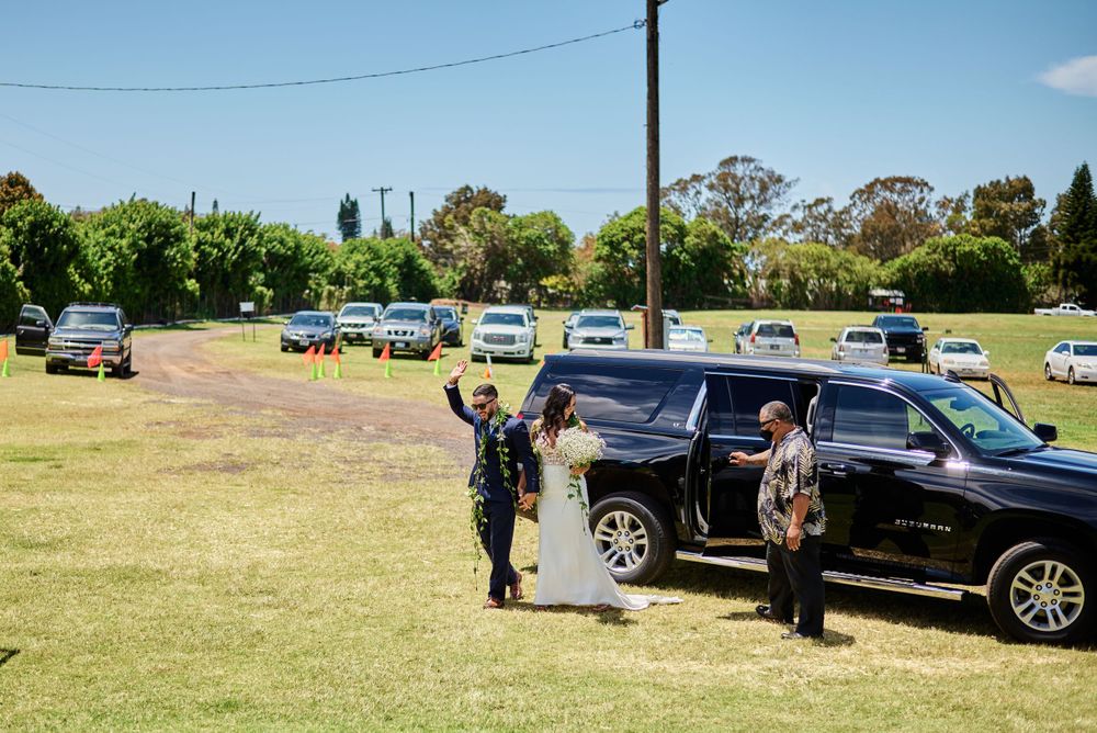 Cars parked in a grassy field at an outdoor event venue on a sunny day.