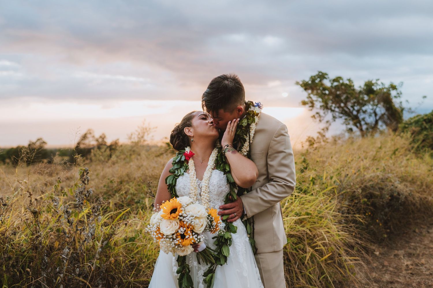 A romantic wedding photoshoot at sunset in a field with golden sunflowers and natural scenery.
