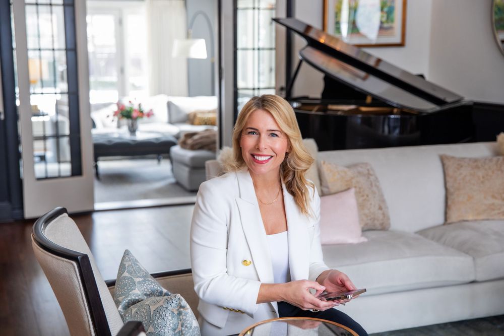 Professional portrait in bright room with piano visible in background.