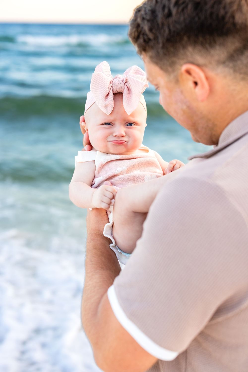 A sweet beach moment captured with gentle ocean waves in the background.