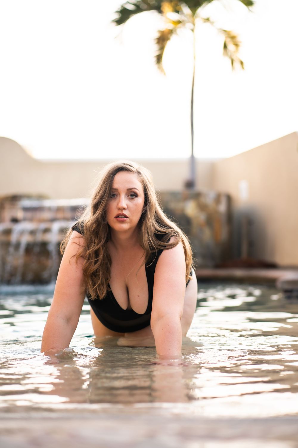 Artistic boudoir photography sequence showing dramatic poses in shallow water with soft lighting.