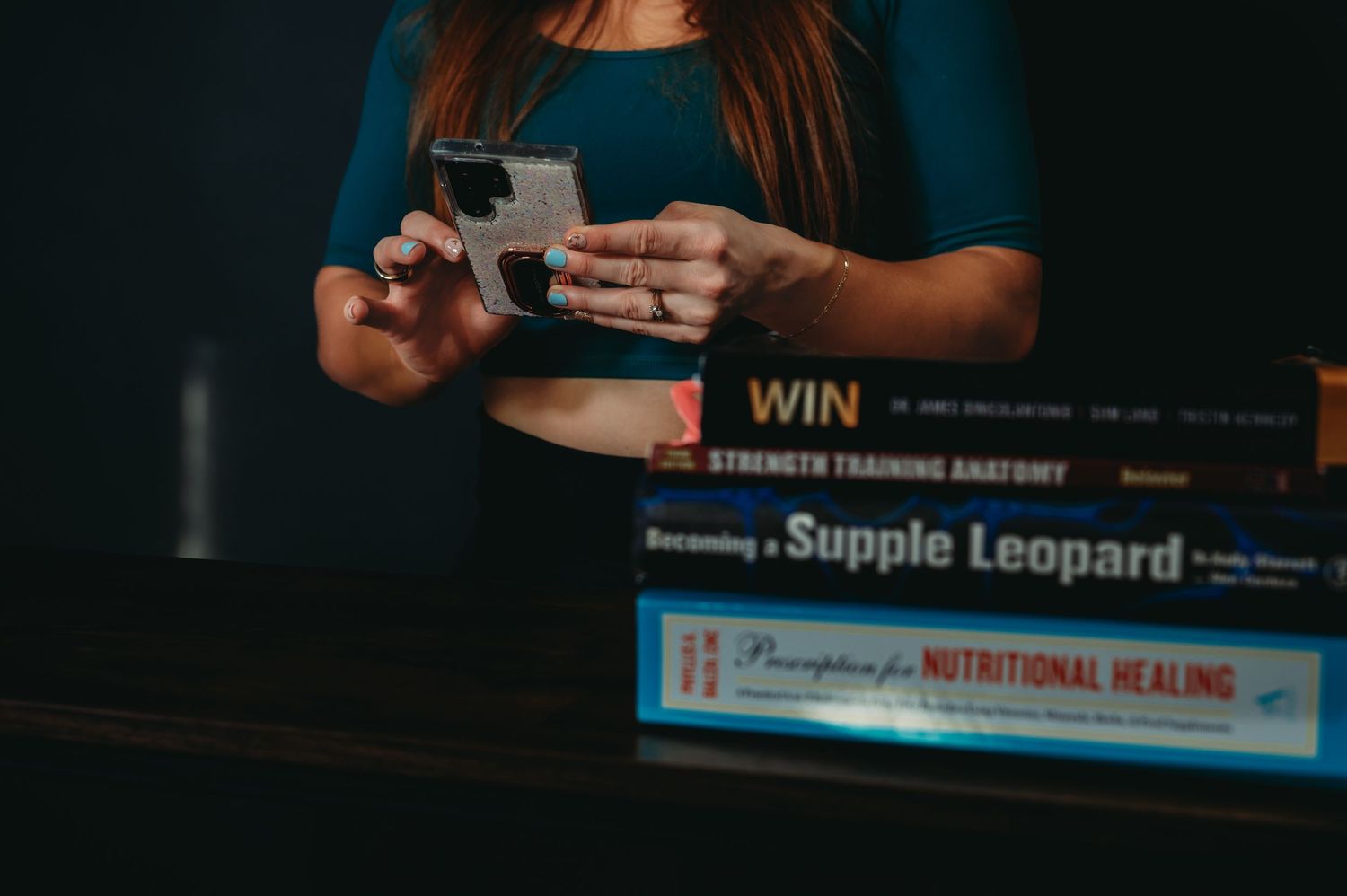Close-up of hands holding books about nutritional healing and health topics.