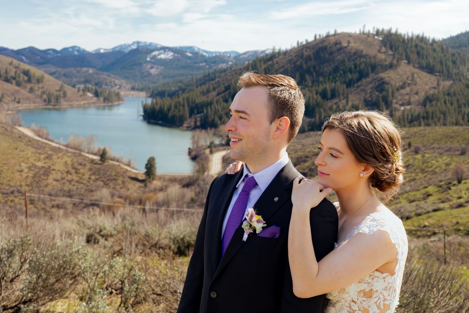 A romantic wedding photo session against a stunning mountain landscape with snow-capped peaks and evergreen forests.