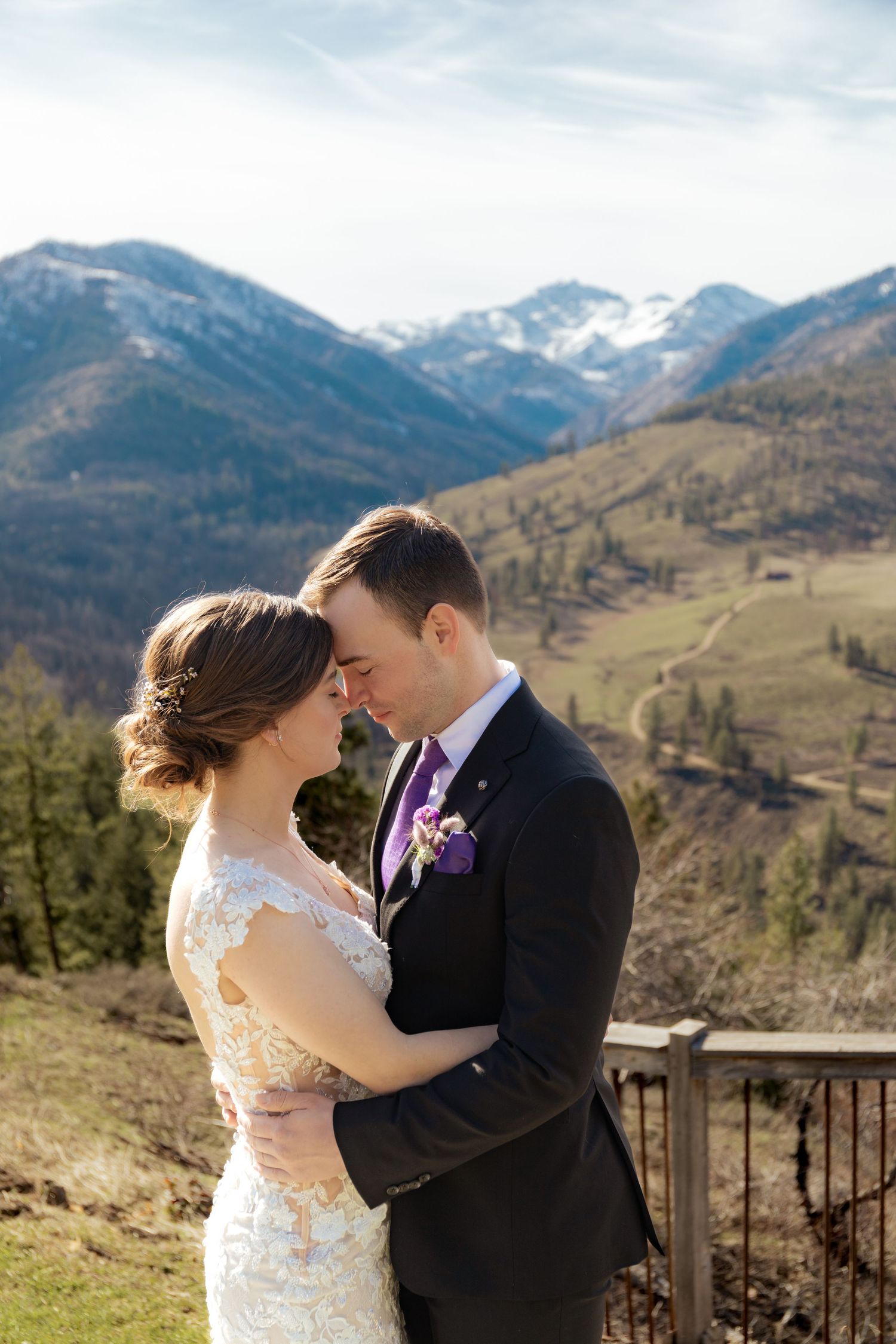 Intimate wedding portraits captured on a scenic mountain overlook with dramatic mountain vistas in the background.