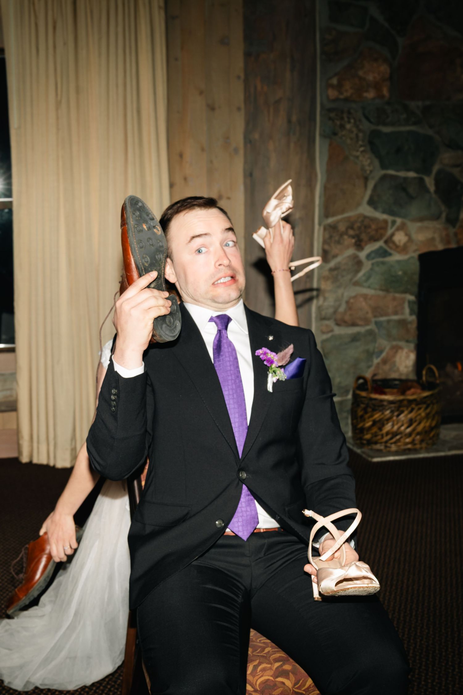 A person in a black suit and purple tie shows expressive reactions in a series of four candid wedding photos.