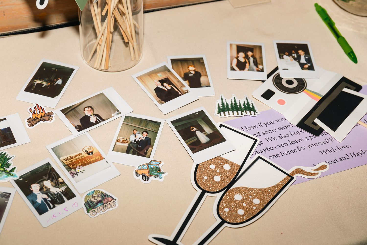Collection of polaroid photos and small items scattered on a wooden surface with natural lighting.