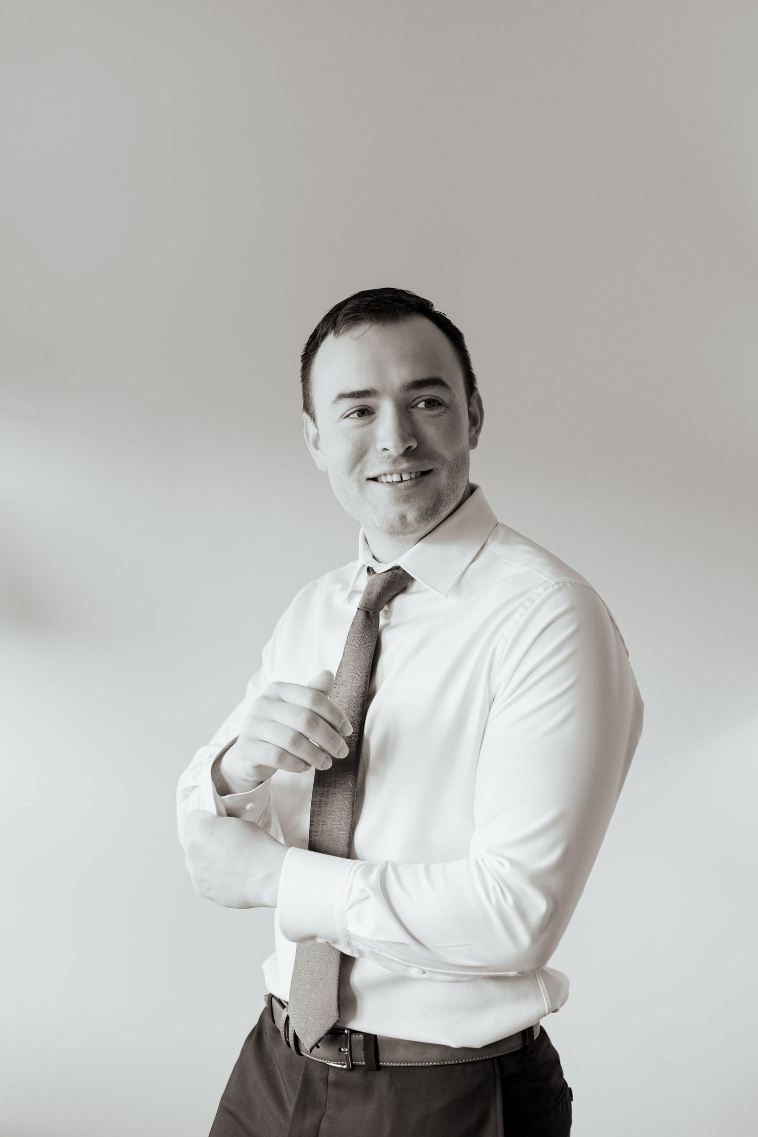 Professional portrait series showing a person in a white dress shirt posing against a light gray background.