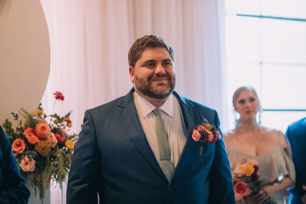 Emotional first look wedding moment between couple in natural window light during intimate indoor ceremony.