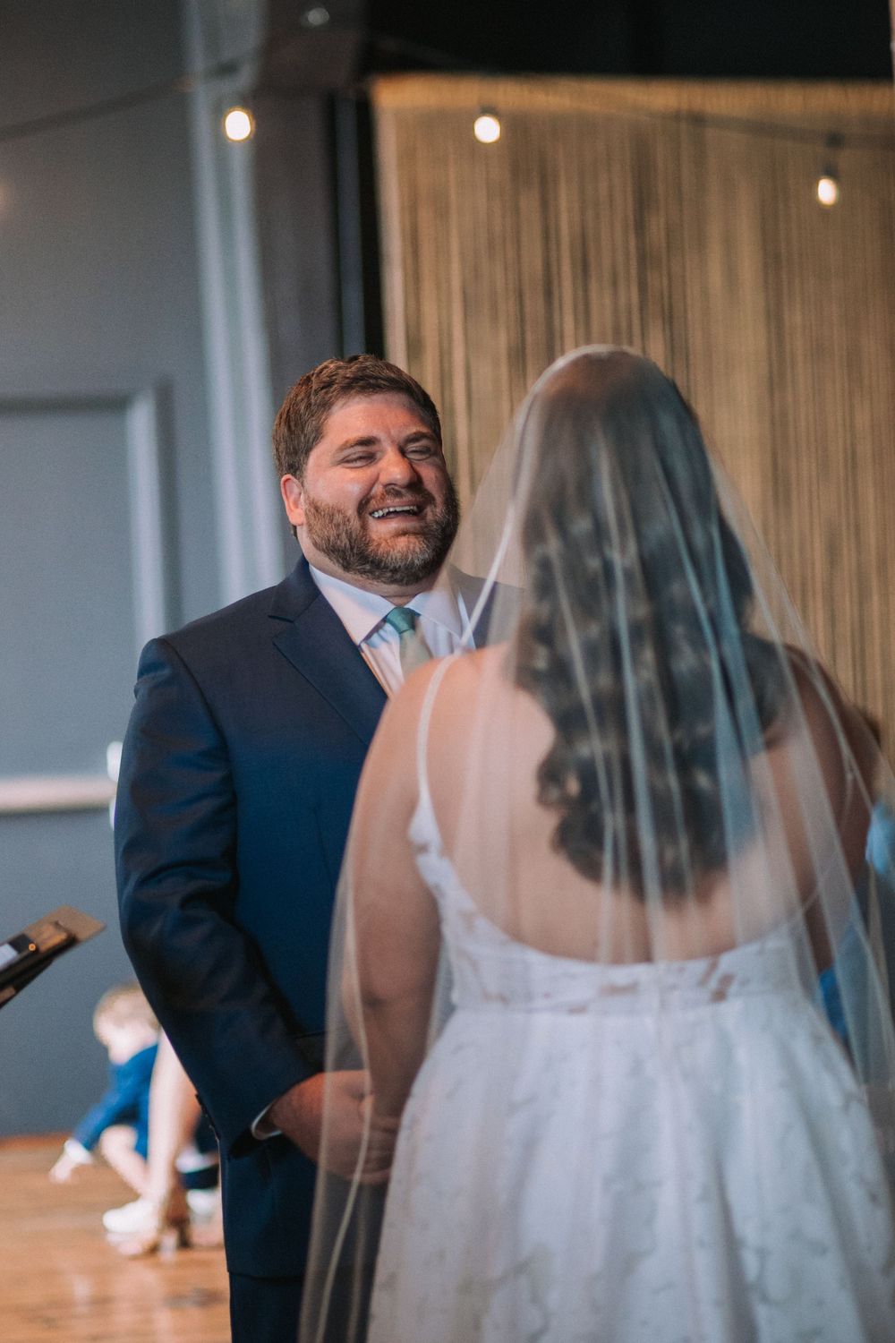 A tender moment between newlyweds during their first dance at an indoor wedding reception.