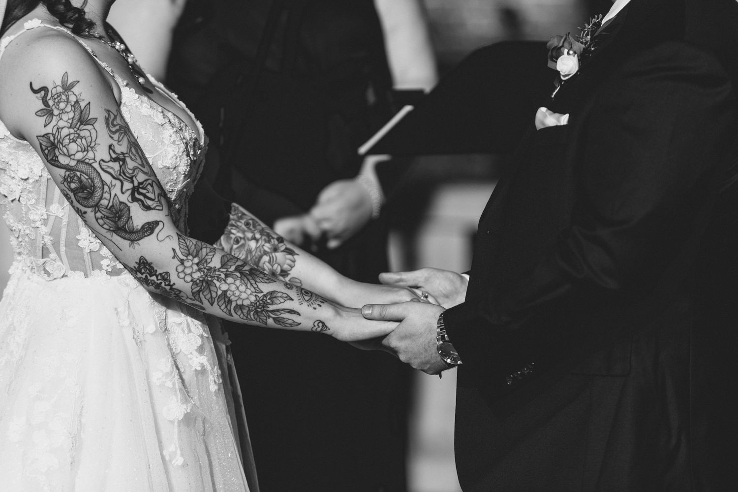 A bride and groom exchange rings during an intimate wedding ceremony while surrounded by loved ones.