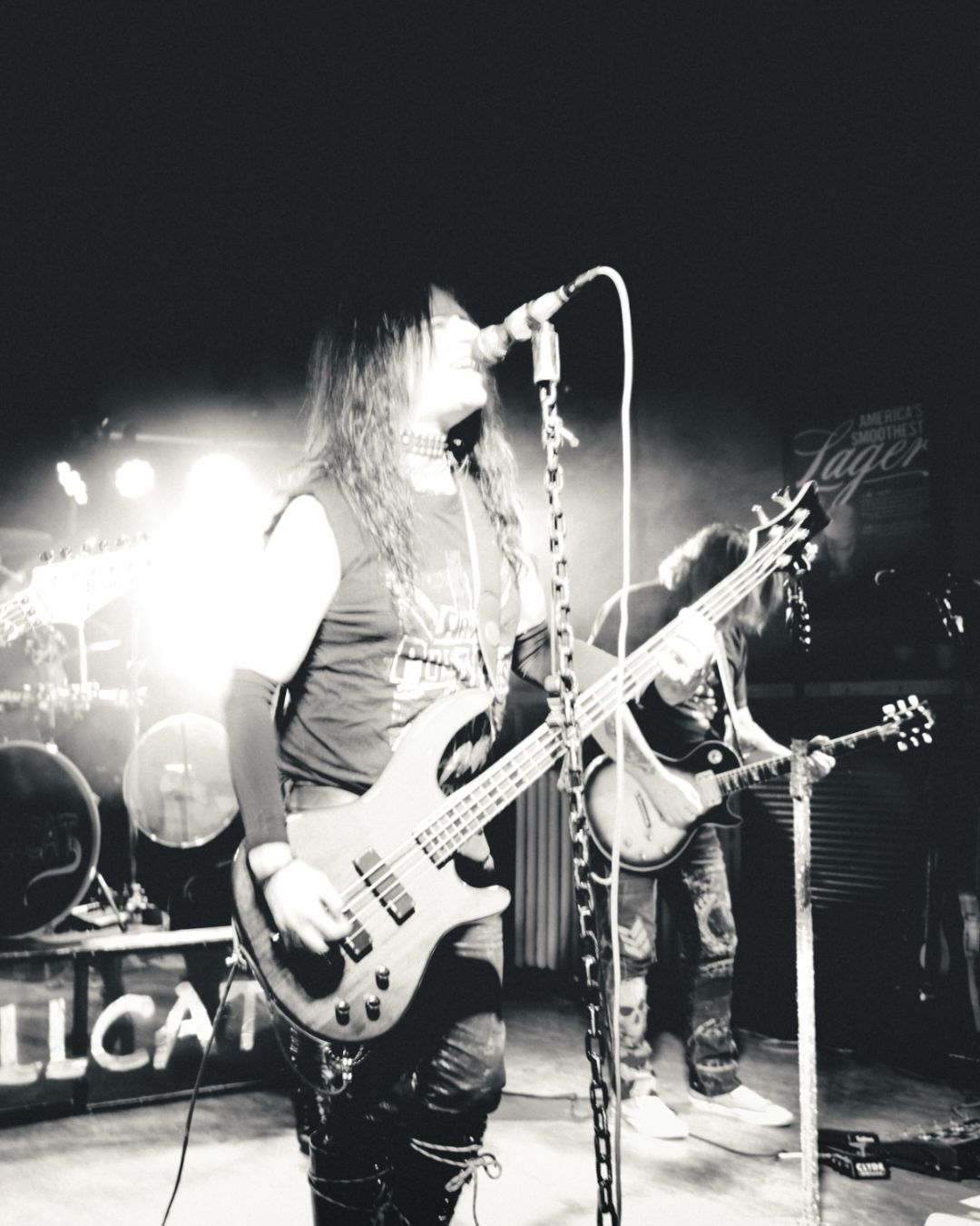 Black and white concert photography of band performing on stage with dramatic lighting.