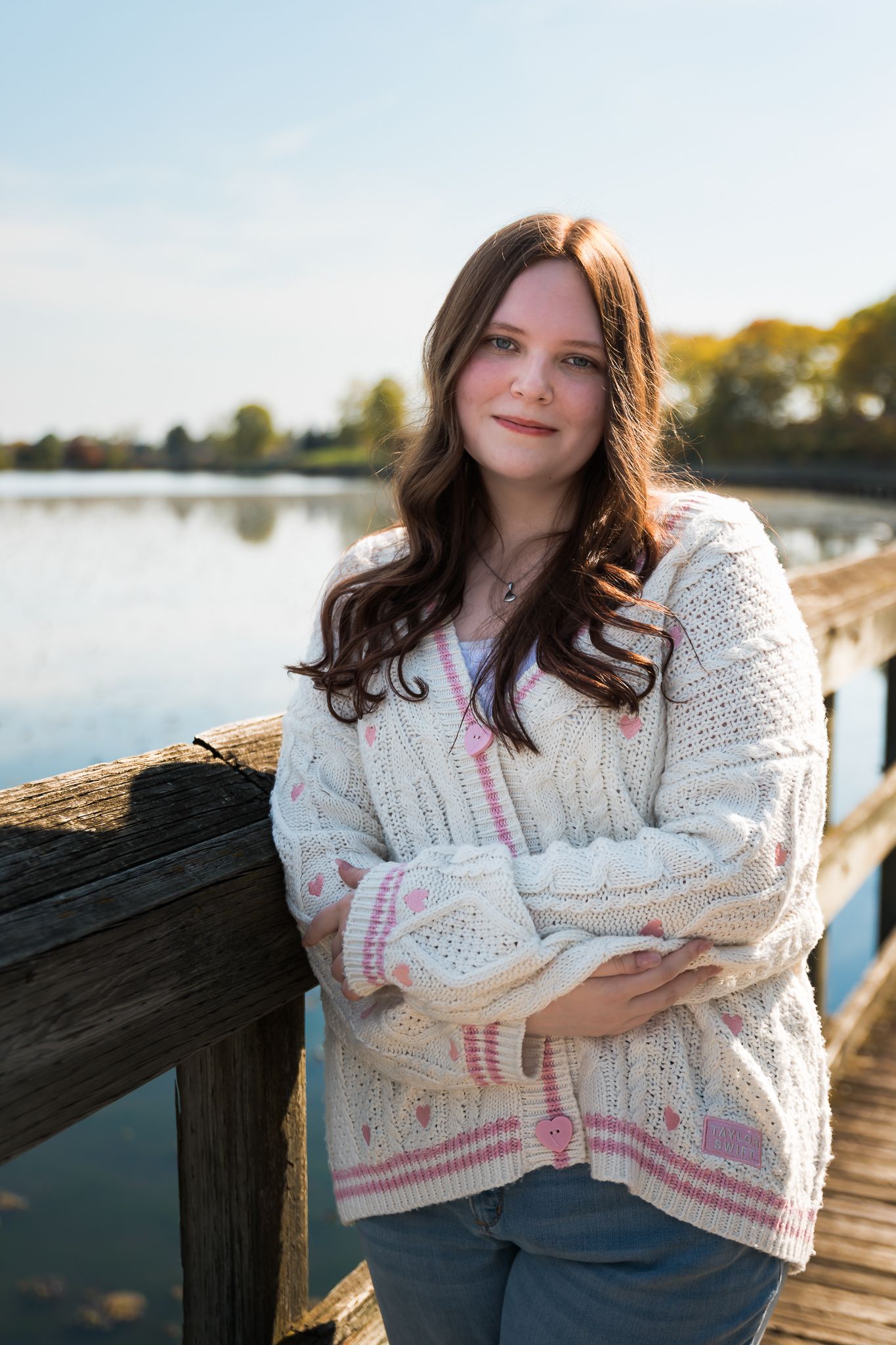 Senior girl is wearing a Taylor Swift lover cardigan and posing for a senior photo at North Bay Park.