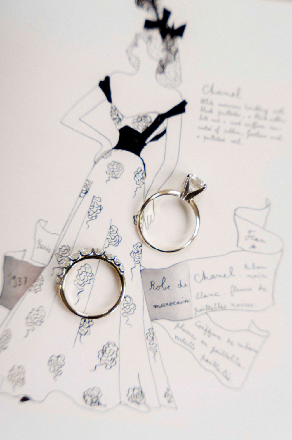 Delicate silver hoop earrings displayed on handwritten notes with decorative blue sketches and patterns.
