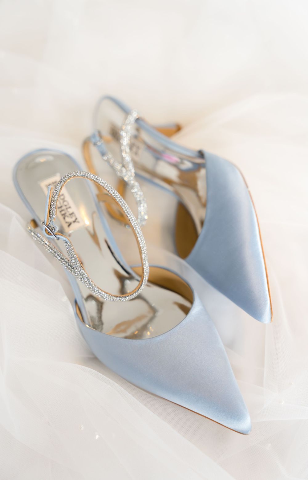 Elegant light blue bridal shoes with sparkly straps displayed on white background.