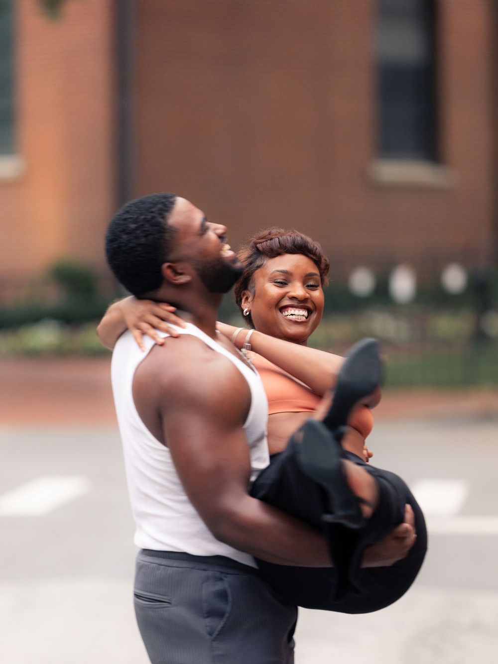Two people embracing and laughing together on an urban street in Downtown Annapolis MD