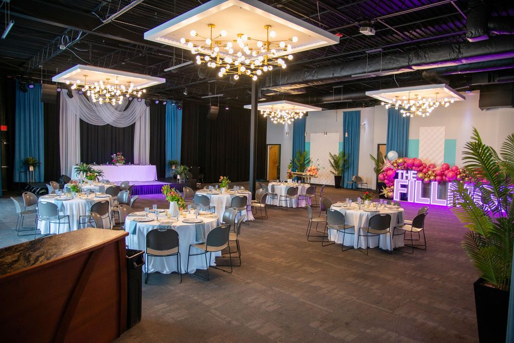 Large event space with elegant chandeliers and blue accent lighting.