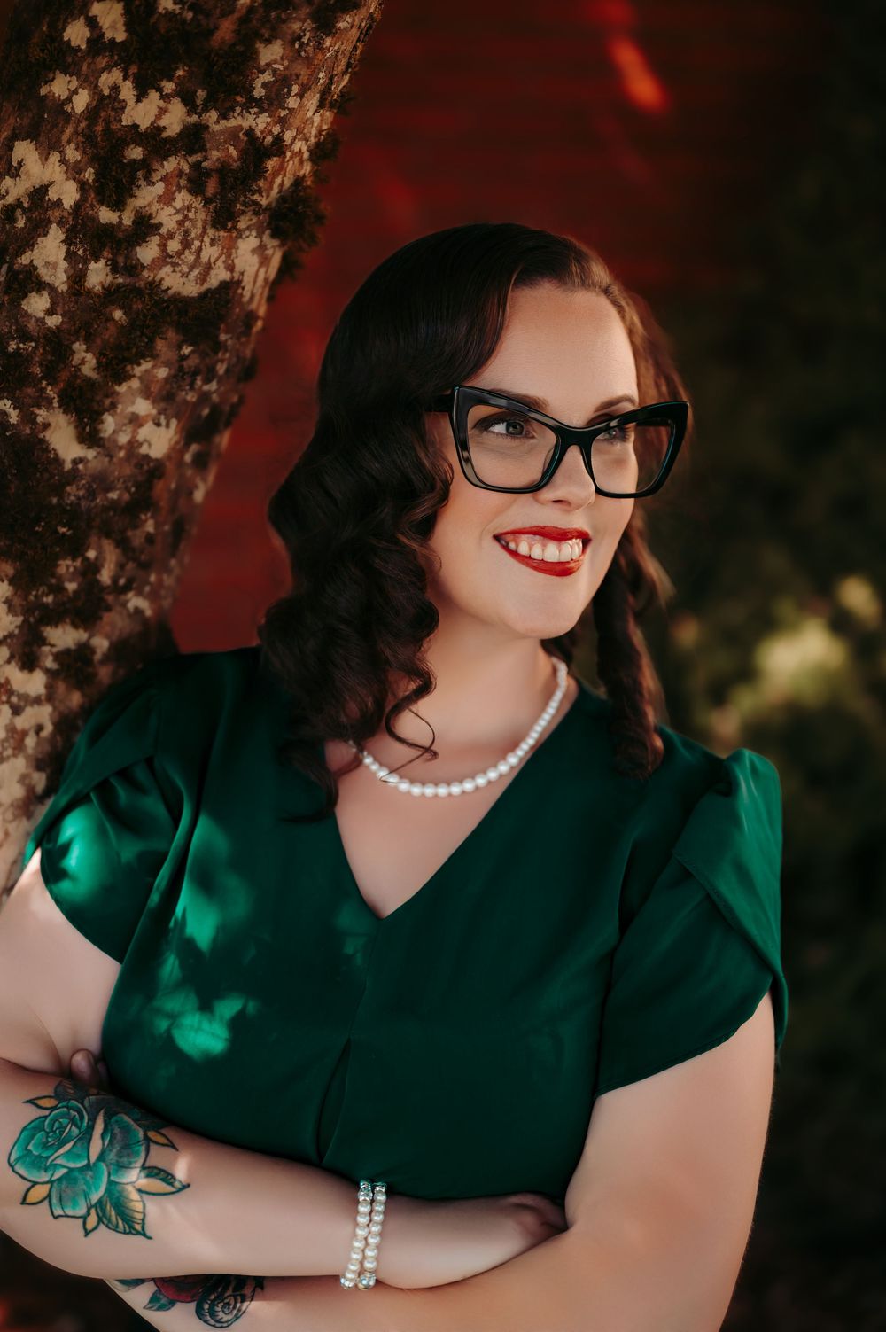 Vintage-inspired portrait with emerald dress, pearl necklace, and cat-eye glasses.