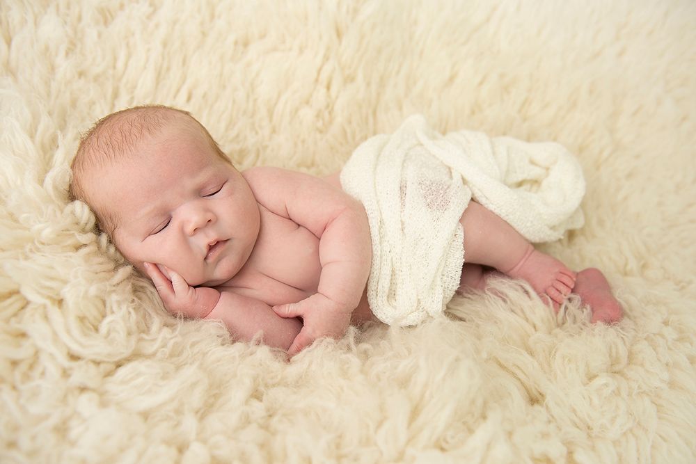 Newborn baby photographed on a neutral flokati blanket