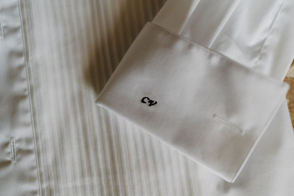 Close-up view of white linen button-up shirt sleeve with cuff detail.