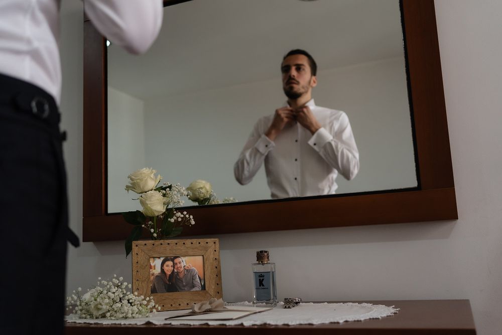 A series of black and white photographs showing someone preparing for a formal event in front of a mirror.