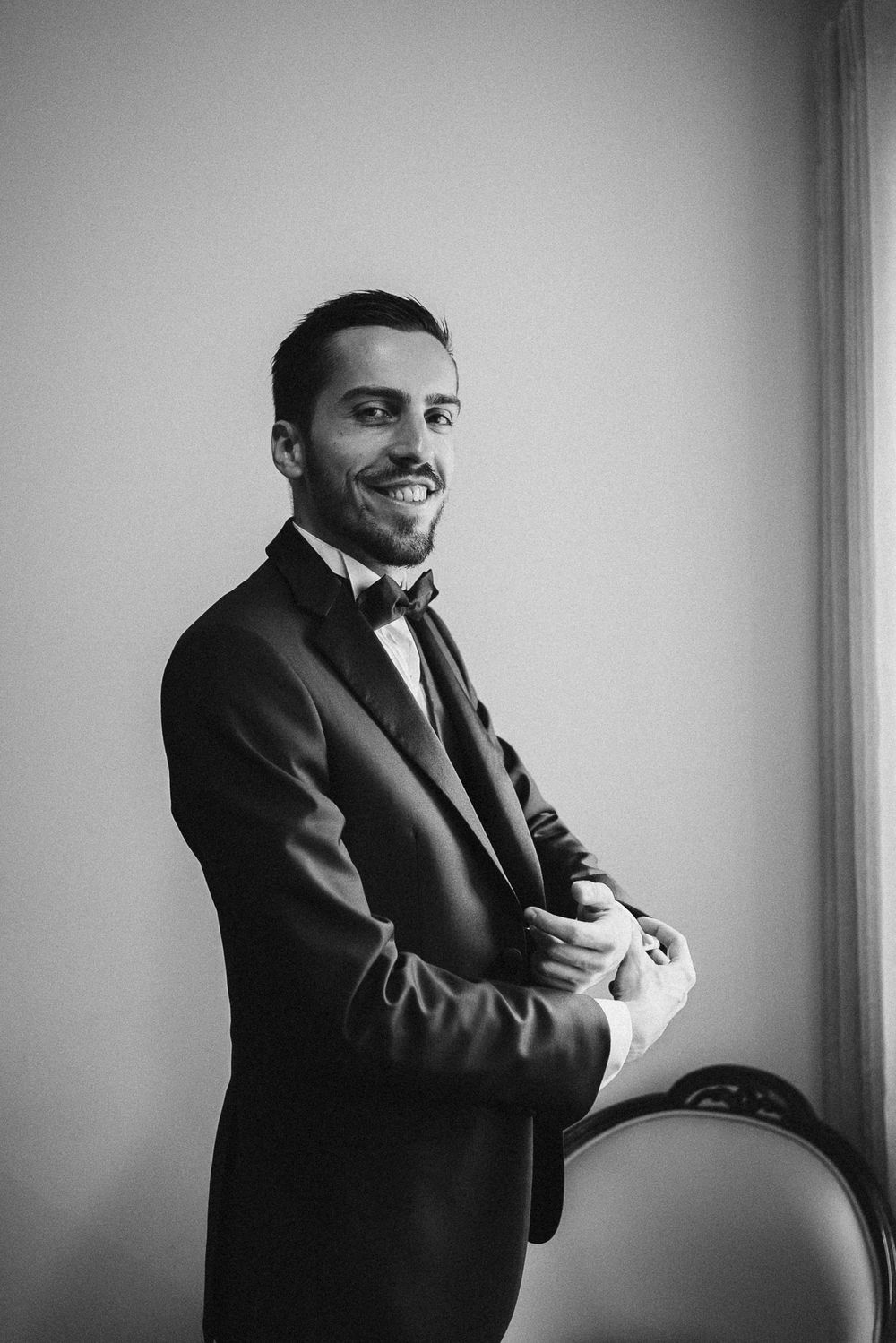 Professional black and white series showing expressions and gestures in formal attire against a plain wall.